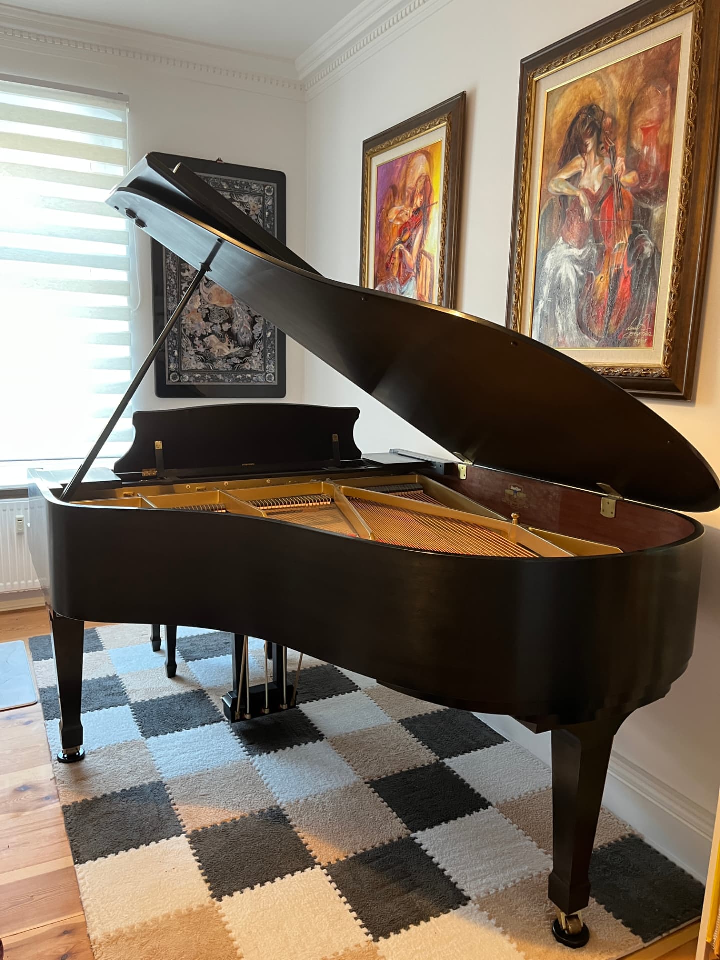 The Kawai grand piano with its lid raised in the Berlin atelier